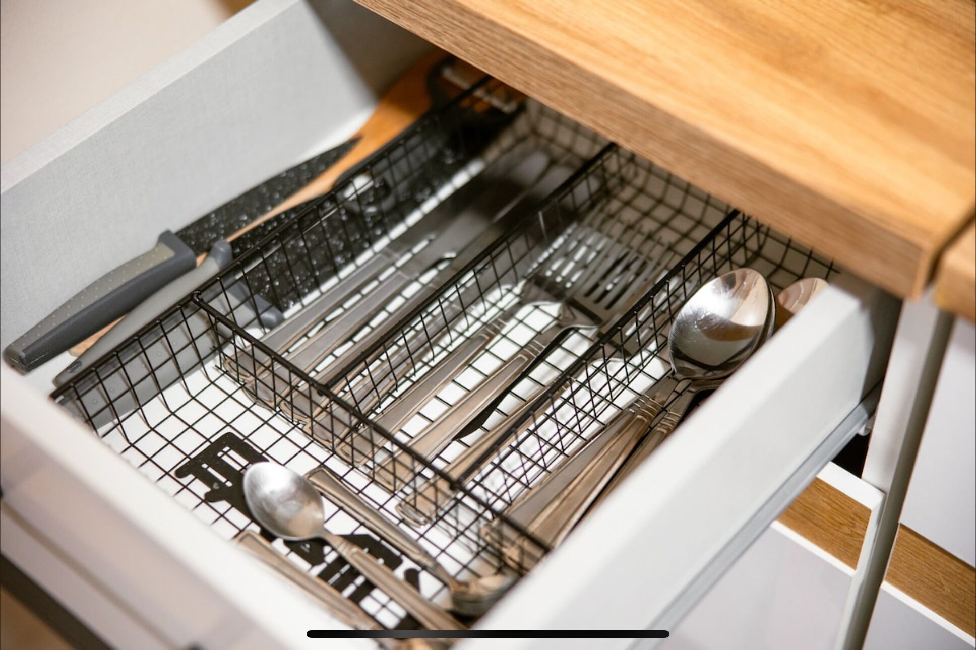 A kitchen drawer with utensils and cookware.