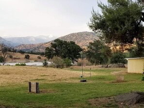 A grassy field with a small pond, trees, and a shed. - Lazy J Ranch-americas Best Value Inn (Three Rivers)