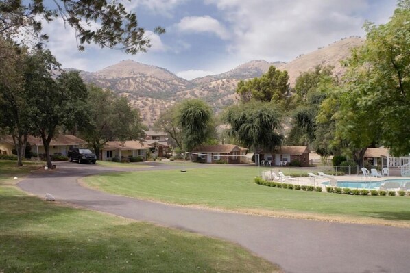 Un barrio residencial con casas, una piscina y montañas al fondo.