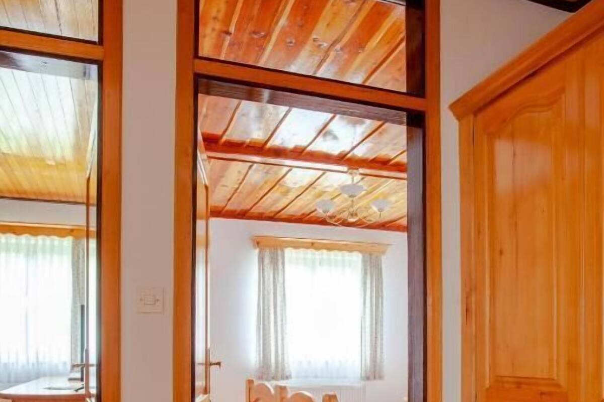 Un interior de madera con una cama, un armario y un ventanal.
