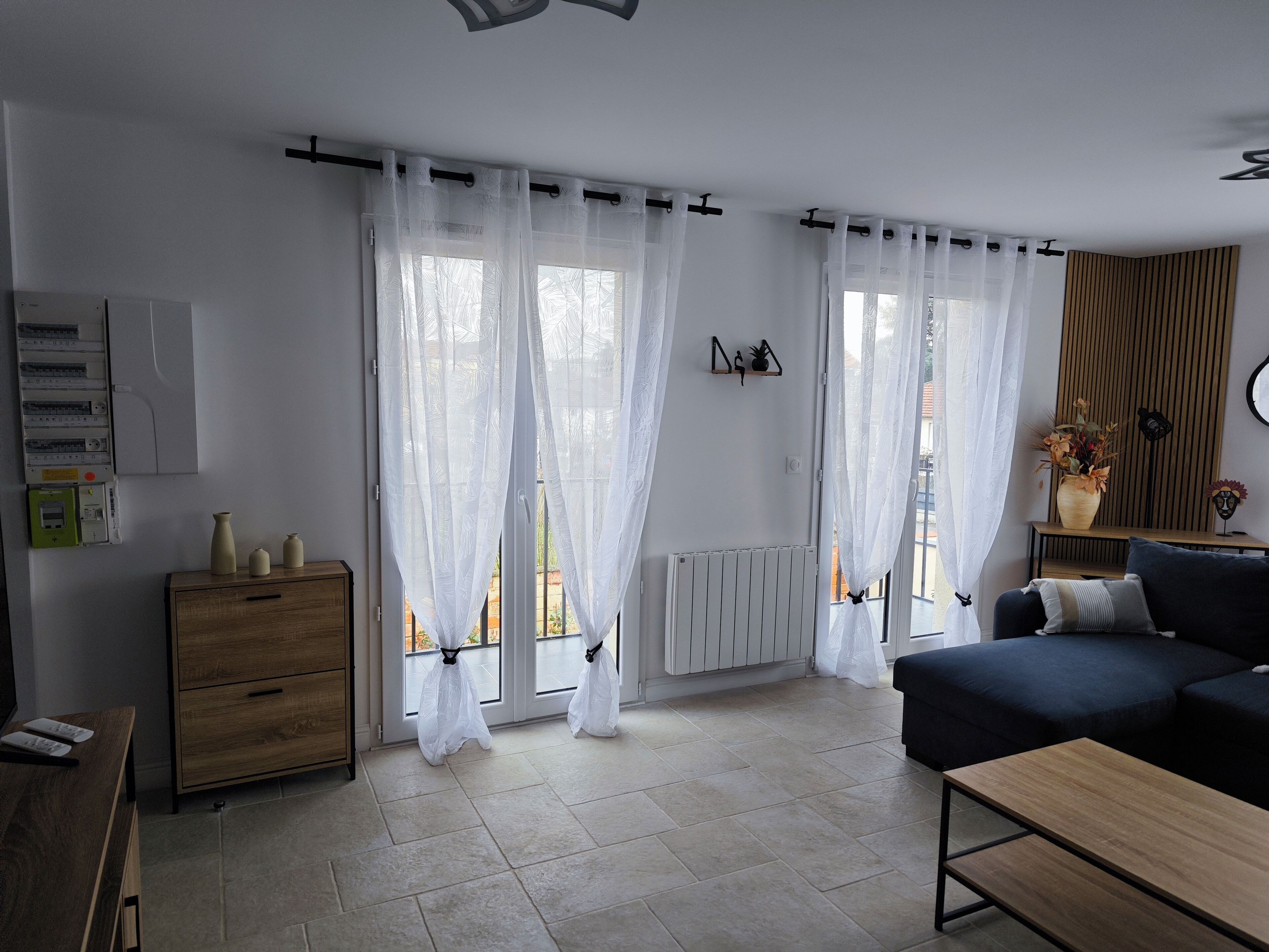 A modern living room with a sofa, a wooden table, and a radiator.