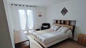 A bedroom with a bed, a desk, and a chair. - Large apartment between Paris - Disneyland - CDG Airport - B.Olympique Vaires (Brou-sur-Chantereine)