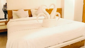 A neatly made bed with a heart-shaped towel arrangement and a white pillow. - Leopard Valley Resort (Kumbhalgarh)