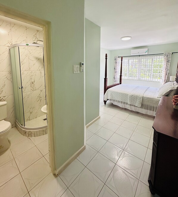 A bathroom with a glass shower enclosure, a toilet, and a sink. - Ocean view villa 6-BR, 6-Bath, 7min walk to free beach (Trelawny Parish)