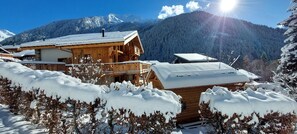 A wooden chalet with a balcony, surrounded by snow-covered trees and mountains in the background. - L'Échappée Chalet sauna 7 bdrms terraces sublime view skiroom close to cable car (Champagny-en-Vanoise)