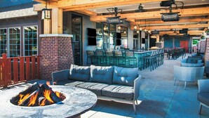 An outdoor patio with a fire pit, seating, and a bar area.