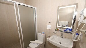 A bathroom with a toilet, sink, and mirror. - Hotel Jojos (Nuwara Eliya)