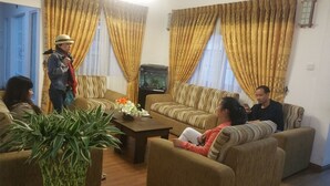 A living room with two sofas, a coffee table, and a fish tank. - Hotel Jojos (Nuwara Eliya)