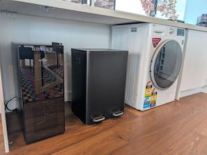 A compact kitchen with a refrigerator, a washing machine, and a microwave. - City and Lake Views with Balcony Pool and Parking (Melbourne)