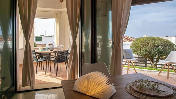 A modern room with a view of a dining area and a tree outside. - Villa Stone and Sea (Villa Almar) (Alghero)
