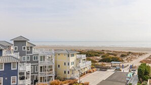 Een hotel aan het strand met meerlaags gebouwen, een parkeerplaats en uitzicht op de oceaan.