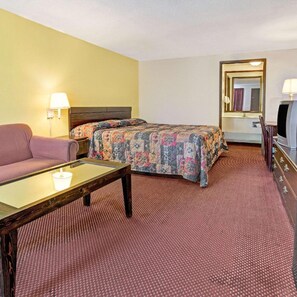 A hotel room with a bed, a sofa, a desk, a TV, and a mirror. - Guest Inn Lebanon (Lebanon)