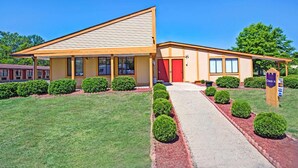 A single-story building with a red door, a covered porch, and a check-in sign. - Guest Inn Lebanon (Lebanon)