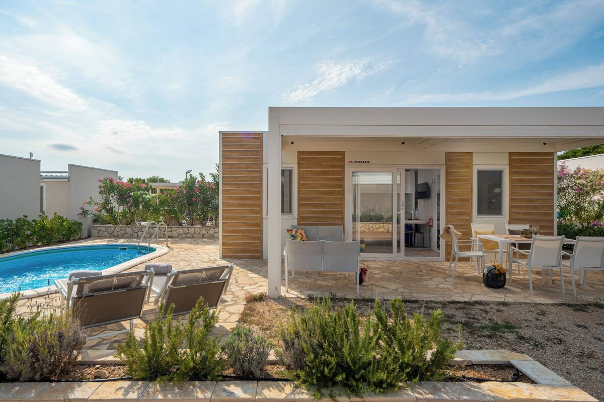 Uma casa moderna com piscina, área de estar externa e um pátio.
