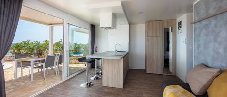 A modern apartment with a kitchen, dining area, and a balcony with a view.