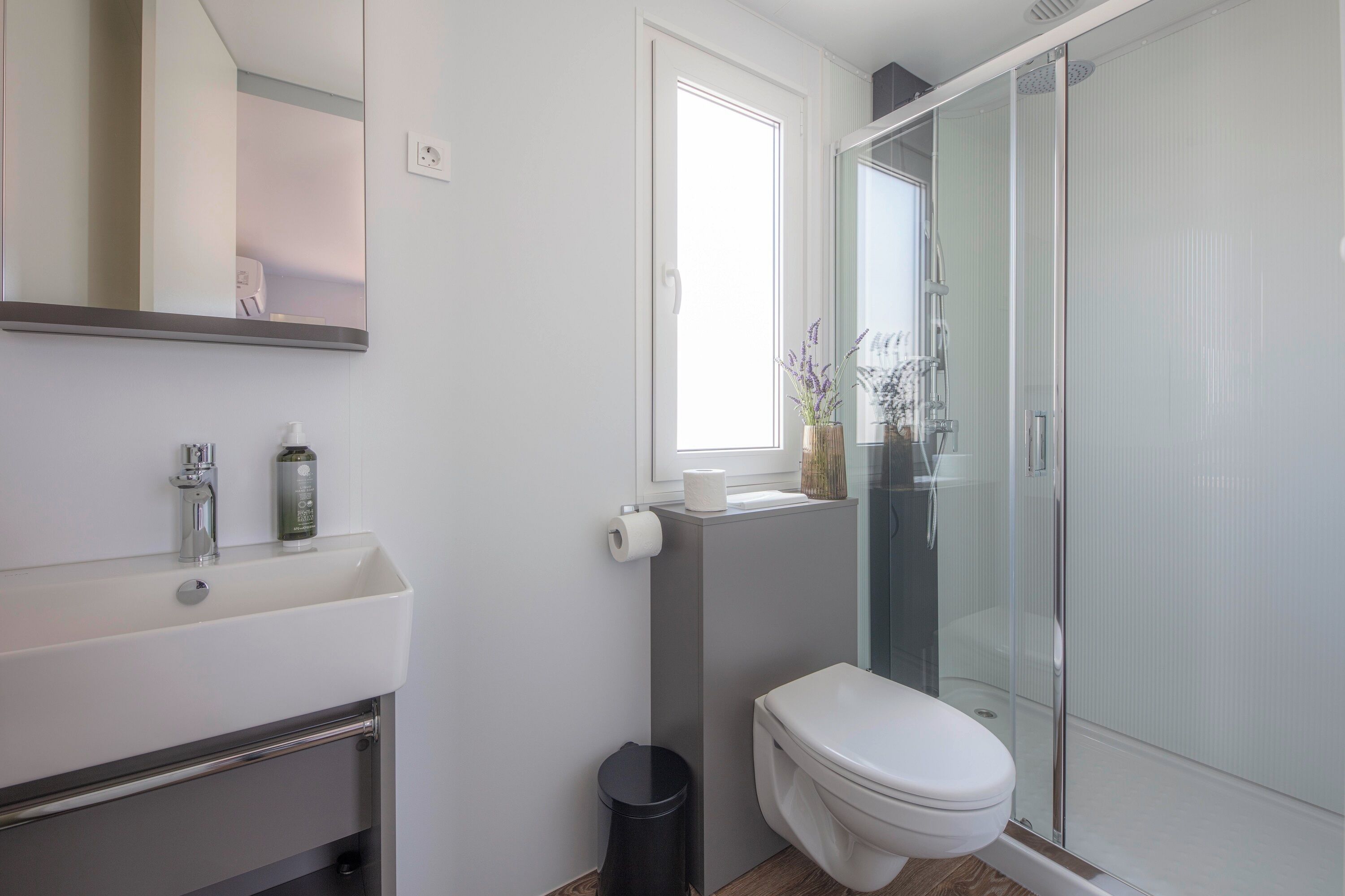 A modern bathroom with a toilet, sink, and shower area.
