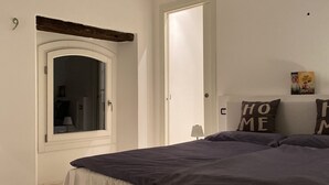 A bedroom with a large bed, a window, and a door. - Lago Lounge & Pool Apartment in Stresa (Stresa)