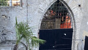 A stone building with a black gate and a window with metal bars. - Lago Lounge & Pool Apartment in Stresa (Stresa)