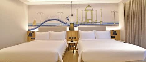 A hotel room with two beds, a small table, and a mural of a bridge and a building.