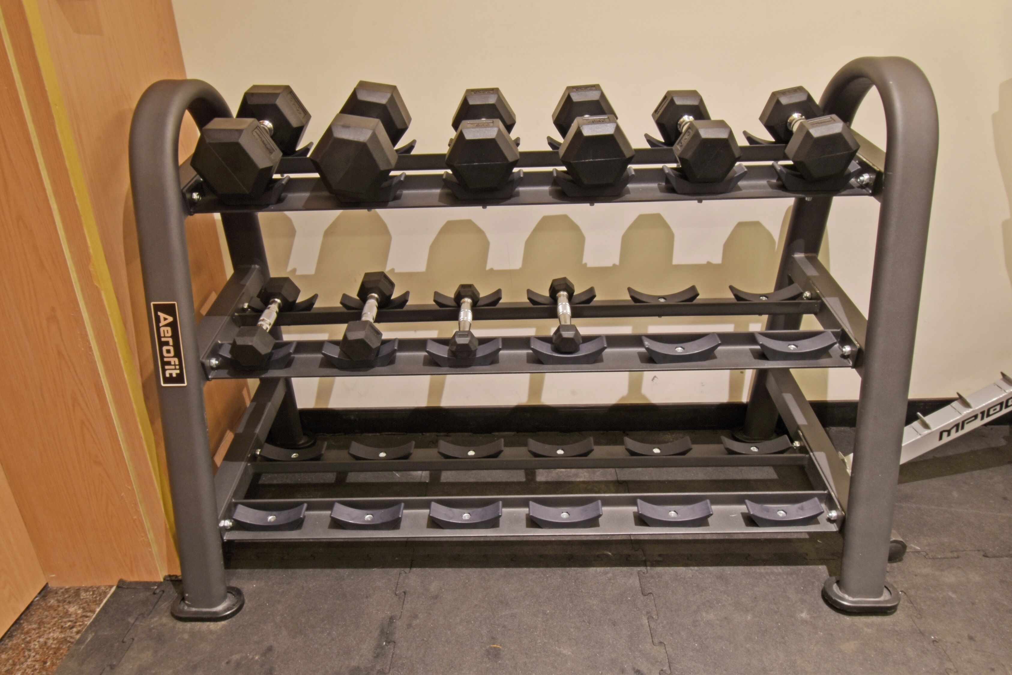 A multi-tiered dumbbell rack with adjustable weights.