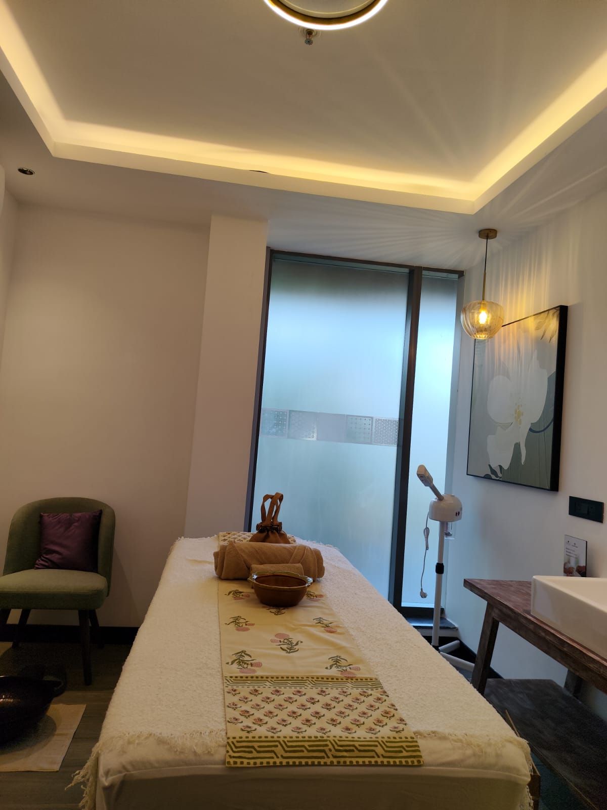 A modern room with a bed, a chair, a table, and a large window.