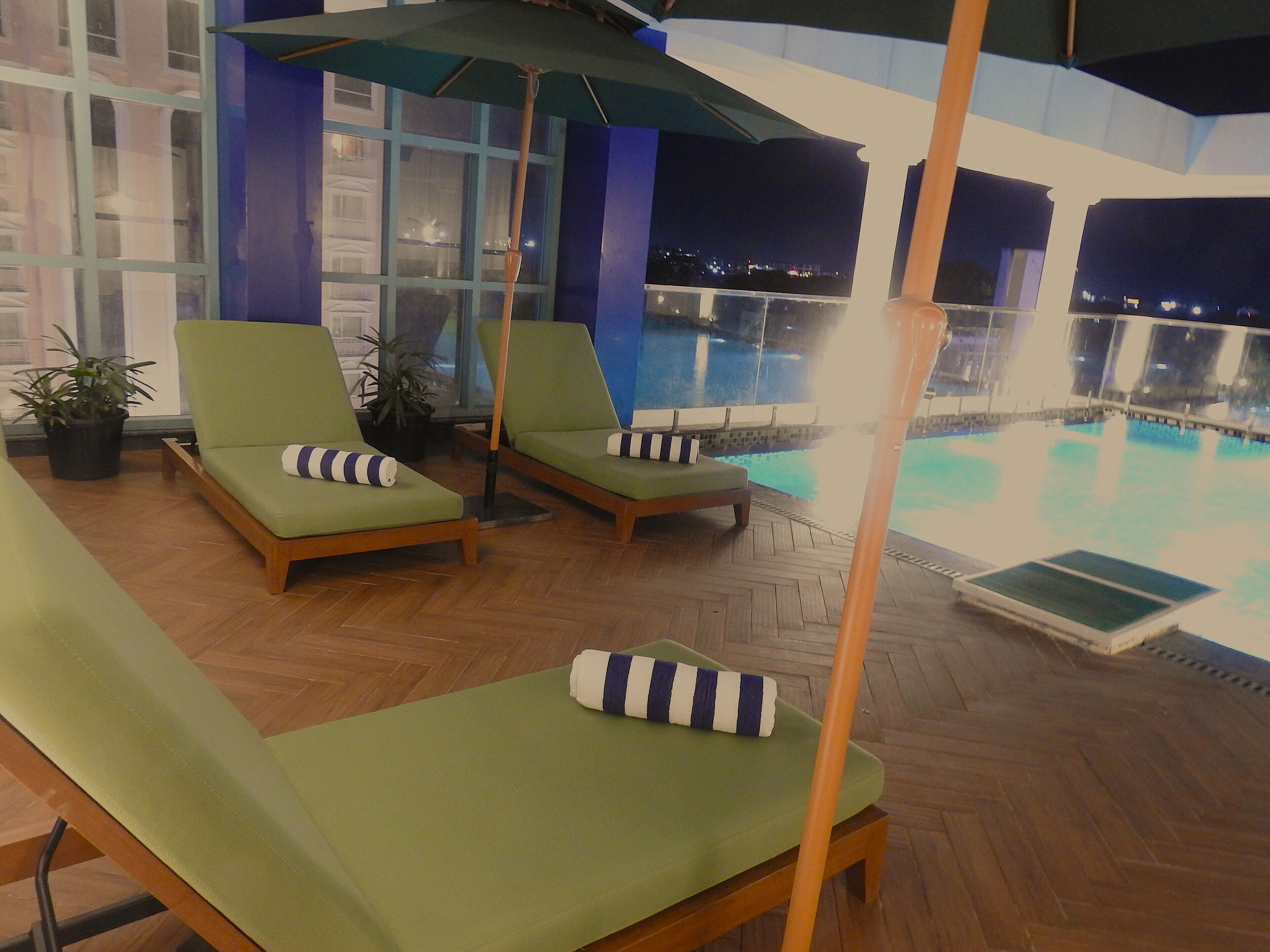 A poolside area with lounge chairs and umbrellas.