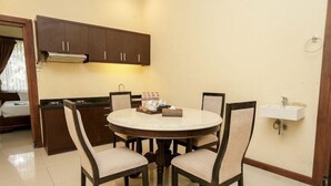 Une cuisine compacte comprenant une table à manger, des chaises et une cuisinière intégrée.