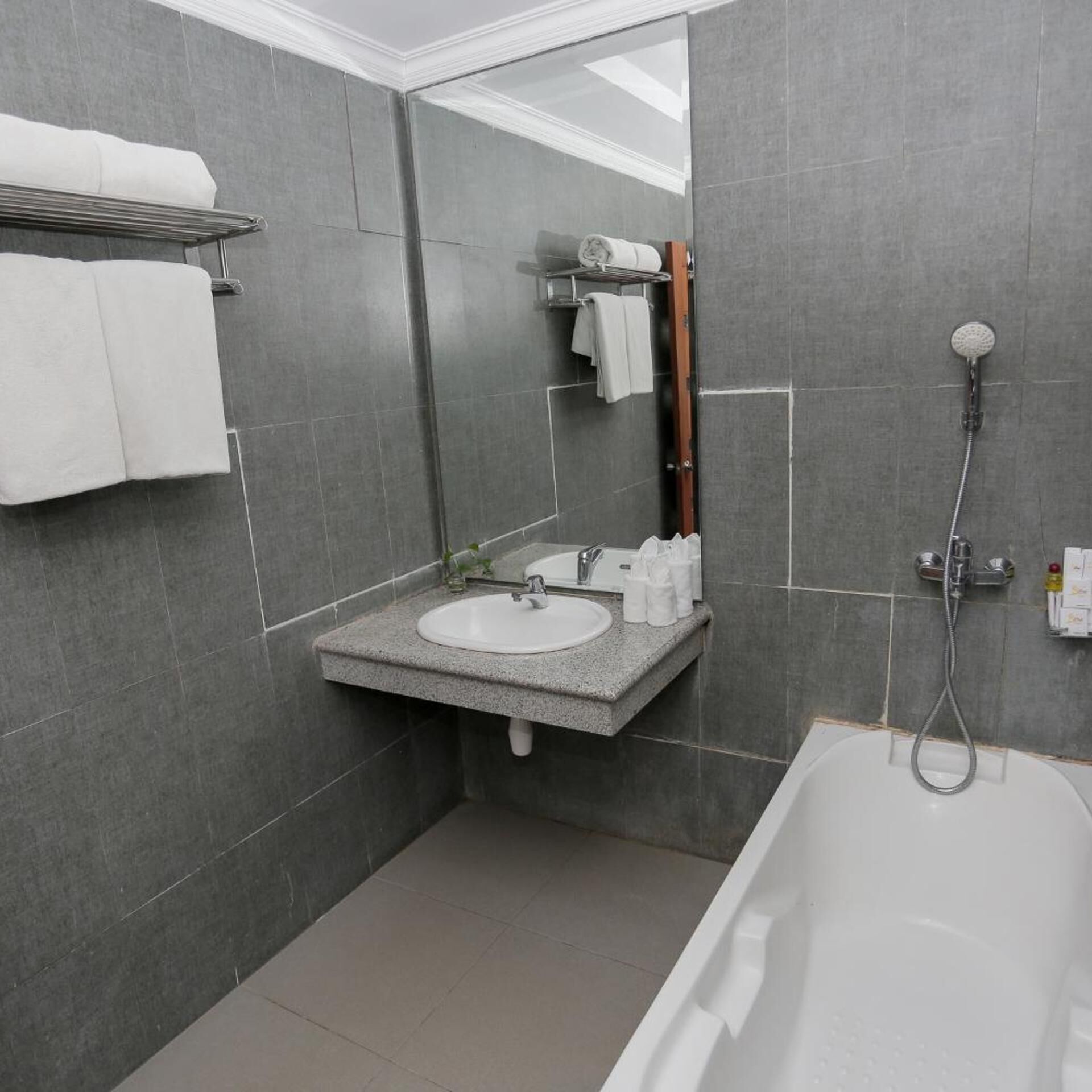 A modern bathroom with a bathtub, a sink, and a mirror.