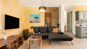 A modern living room with a sectional sofa, a wooden coffee table, and a flat-screen TV mounted on the wall. - Villa Isla Blue 2 pool&welness Krk by Villas Guide (Vrbnik)