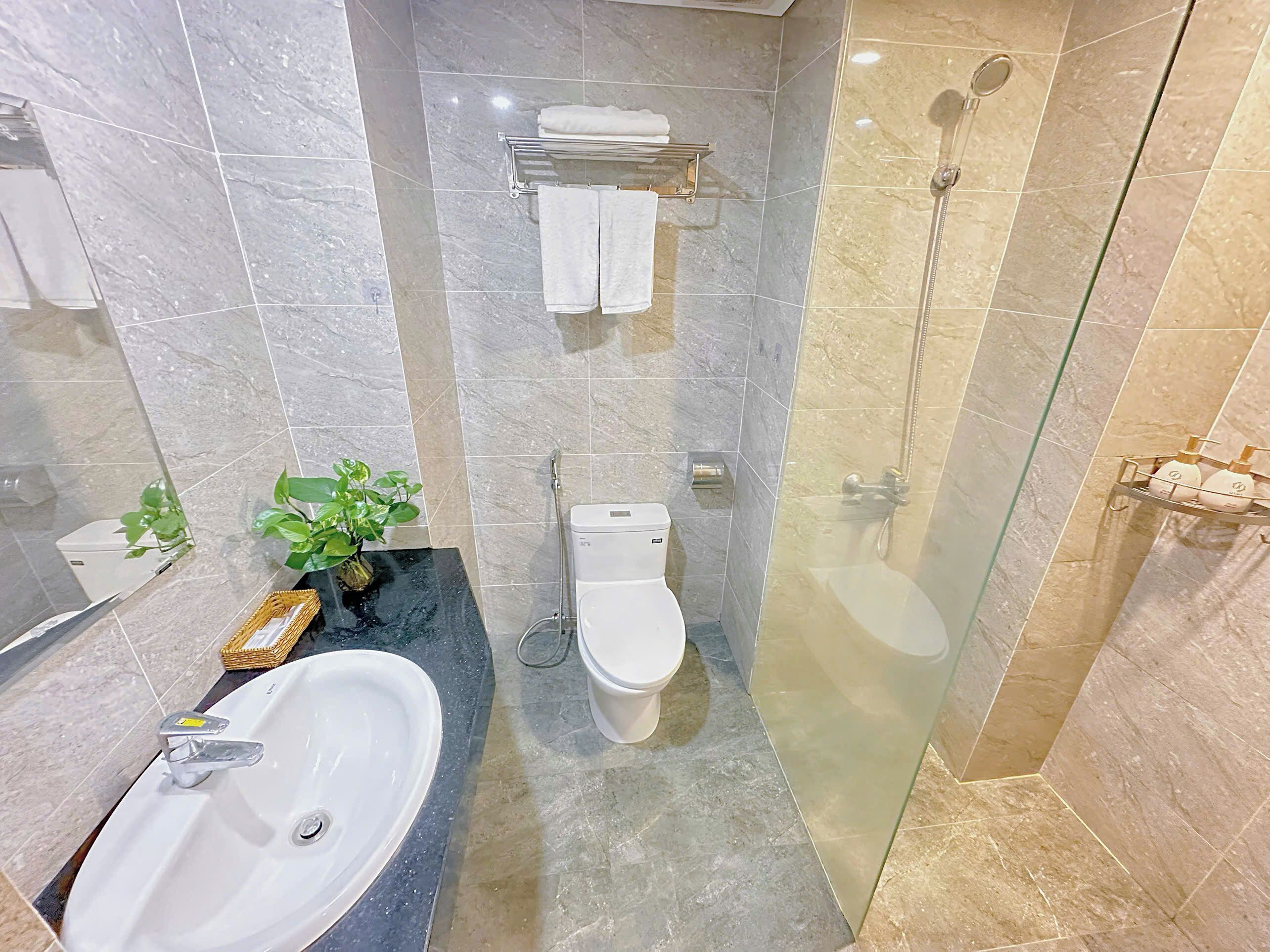 A modern bathroom with a sink, toilet, and shower.