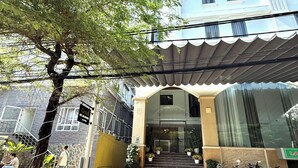 The entrance of Gold Villa with a covered walkway, potted plants, and parked motorcycles. - Gold Hotel & Apartment Da Nang (Da Nang)