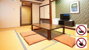 A traditional Japanese-style room with tatami flooring, a low wooden table, a television, and a refrigerator. - Toki Resort Hakuba (Hakuba)