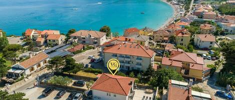 A coastal residential area with houses, a swimming pool, and a clear view of the sea.