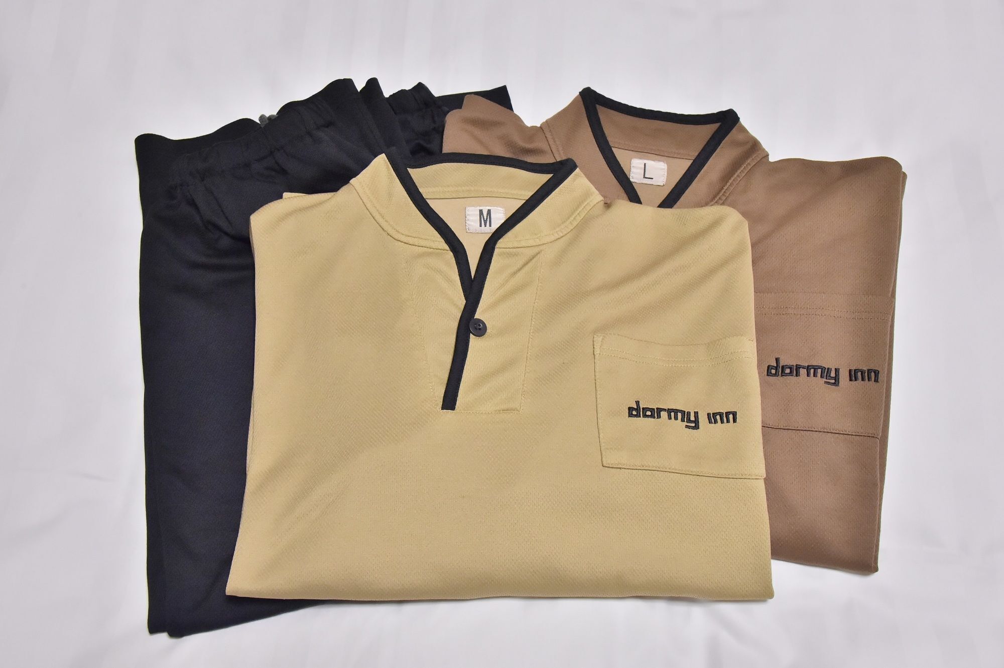 A collection of folded shirts in different colors and sizes.