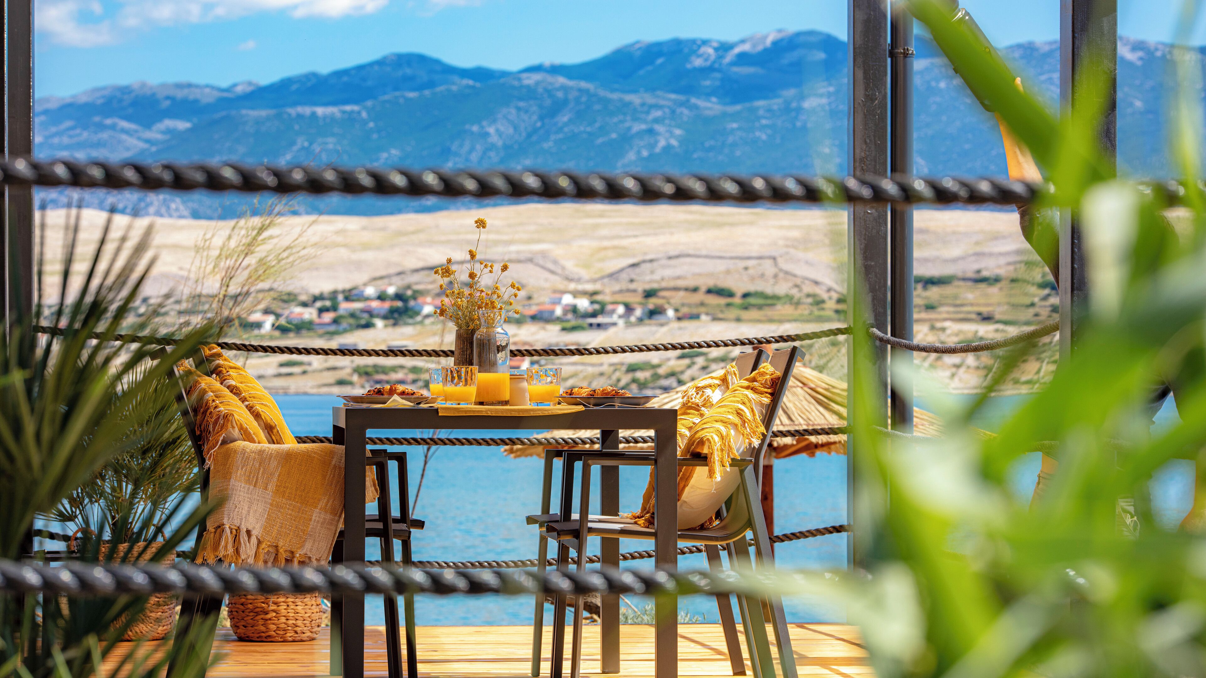 Ein Tisch mit Frühstücksangeboten und Blick auf eine Berglandschaft.