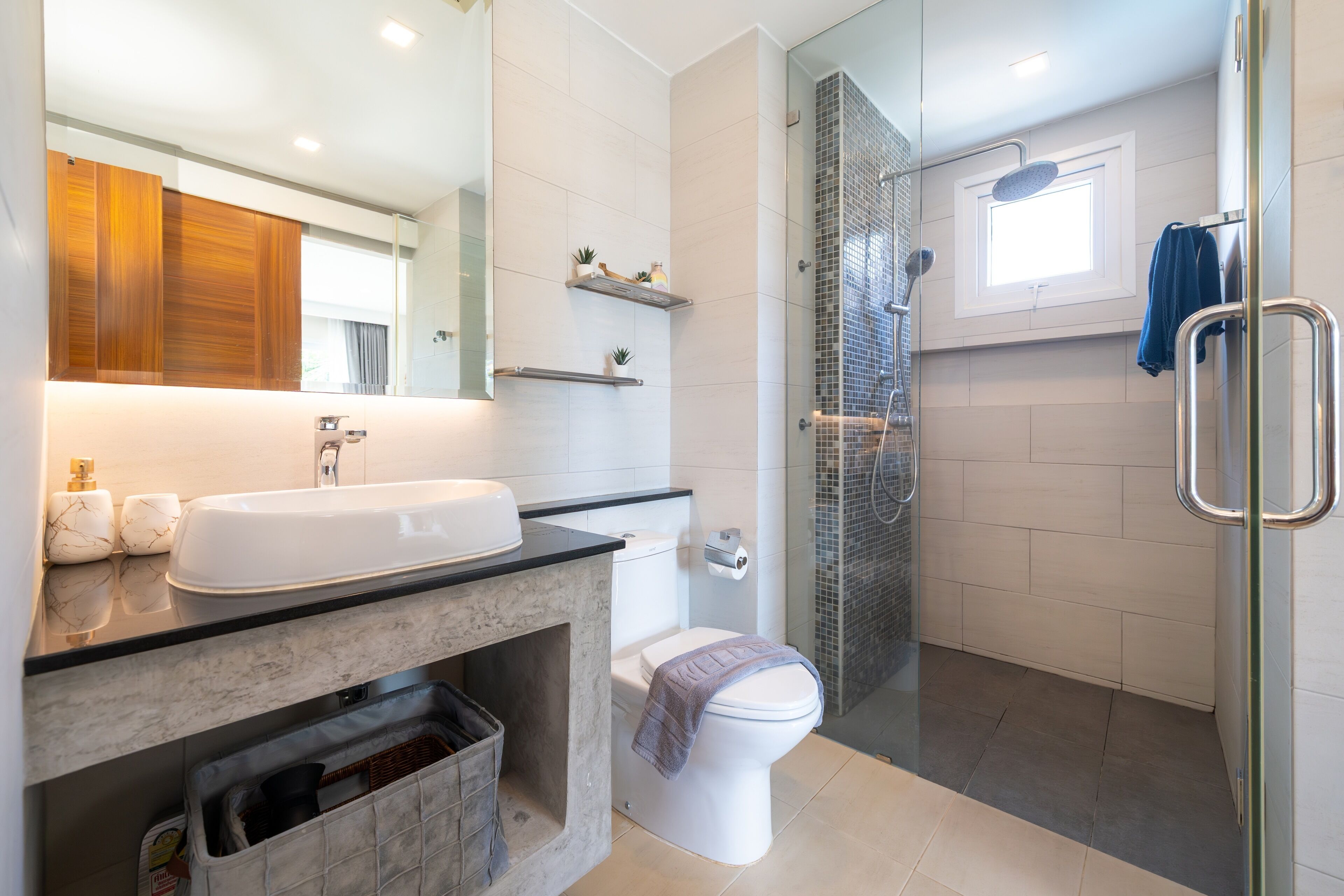A modern bathroom with a large sink, toilet, and shower area.