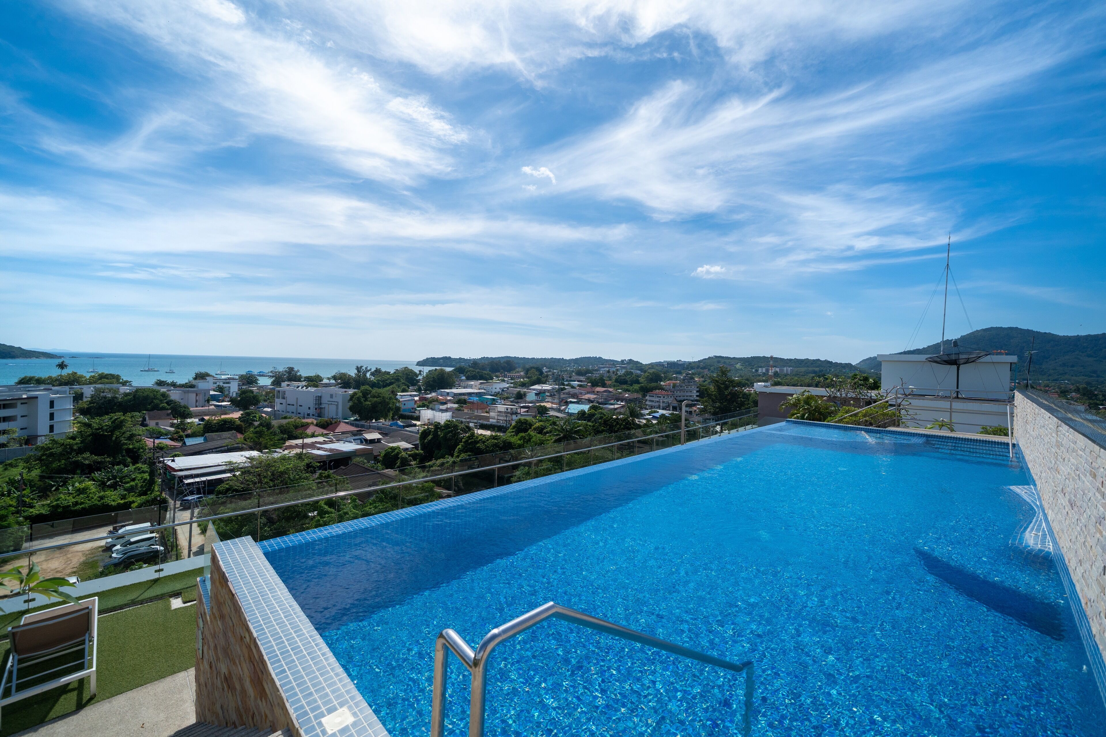 A rooftop infinity pool with a clear view of the city and ocean.