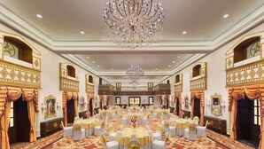 A banquet hall with round tables, chandeliers, ornate wall decorations, and a patterned carpet. - Welcomhotel by ITC Hotels, The Savoy, Mussoorie (Dehradun)