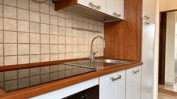 Een koffiezetapparaat/waterkoker, een koelkast, een oven, een waterkoker