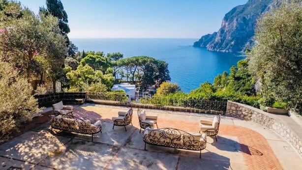 Eine Terrasse mit Sitzgelegenheiten und Blick auf die Küstenlandschaft.