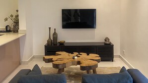 Uma sala de estar moderna com sofá, mesa de centro, TV e lareira.