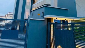 Um edifício moderno com estrutura em vários andares, varandas e entrada com portão.