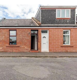 A two-story brick building with a flat roof, a front door, and two windows. - modern luxury cottage (Ayr)