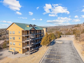 A multi-story building with balconies and a parking lot. - Clean and cute family friendly 2 bedroom condo right next to Silver Dollar City. (Branson)