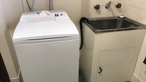 A compact washer and dryer unit with a stainless steel sink and cabinet. - City Central Motor Inn And Apartments (Warrnambool)