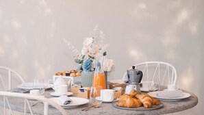 A breakfast setup with croissants, pastries, a coffee pot, and a vase of flowers on a table. - Borgo Mezzo Monte. Panoramic Sea View,Jacuzzi and Concierge by Feeling Italy (Sorrento)