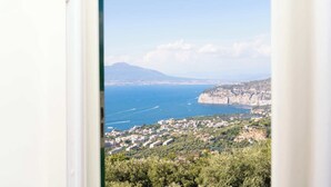 A coastal town with a view of the sea and a mountain in the distance. - Borgo Mezzo Monte. Panoramic Sea View,Jacuzzi and Concierge by Feeling Italy (Sorrento)