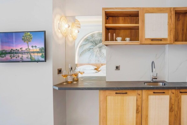 A modern kitchen with wooden cabinets, a marble countertop, and a built-in wine rack. - Drossia Hotel (Hersonissos)