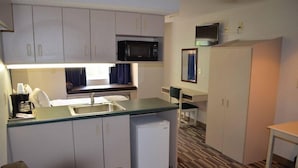 A compact kitchenette with a microwave, sink, and small refrigerator.