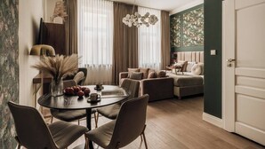 A modern living room with a sofa, a dining table with chairs, and a large window with curtains. - White Lotus by Fragola Collection (Kraków)